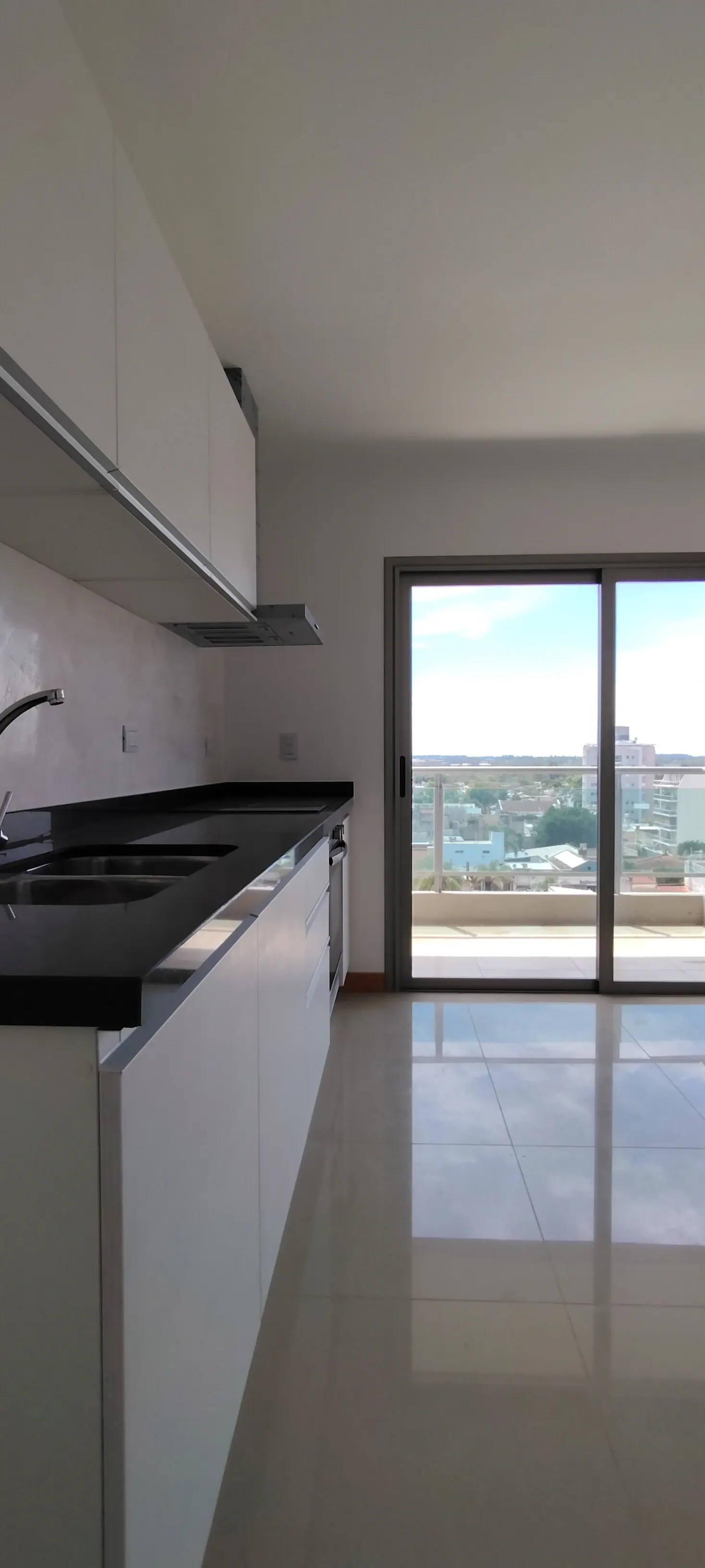 Cocina en L con mesada, bacha y balcón con vista panorámica
