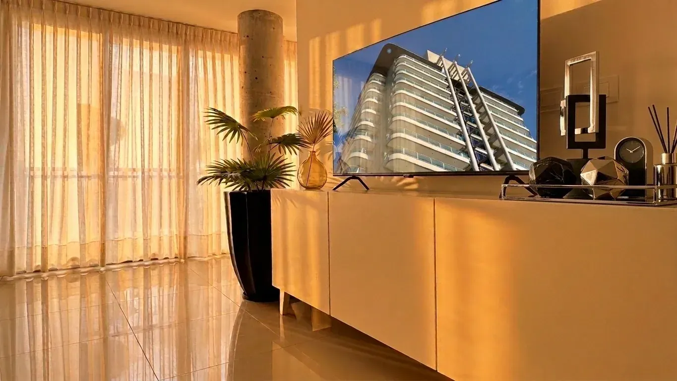 Living con smart TV, mueble bajo y cortinas
