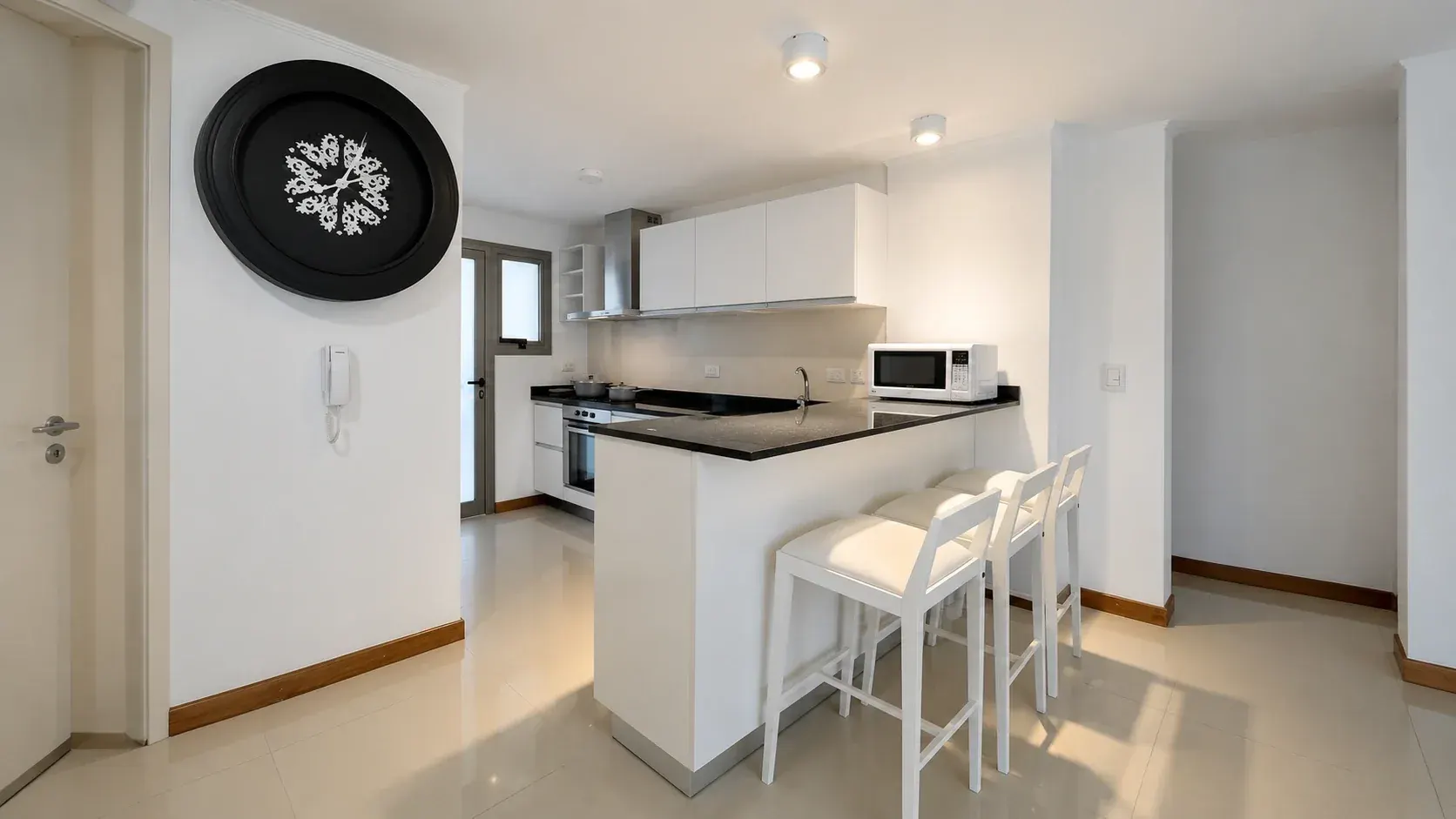 Cocina integrada en L con barra desayunadora y banquetas
